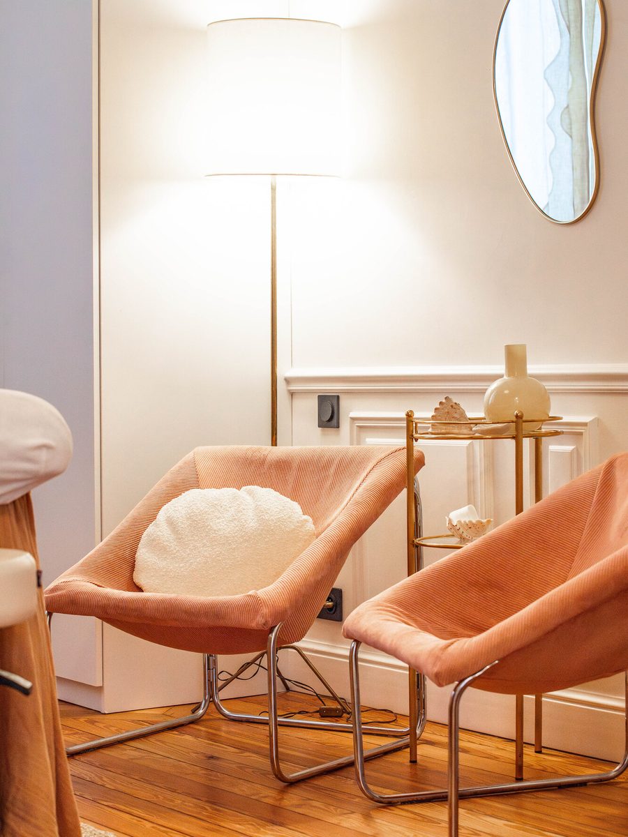 Deux fauteuils de velours rose dans une pièce claire.